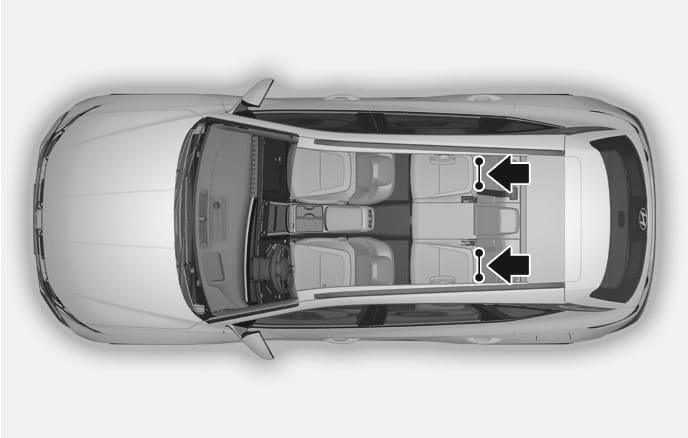 2025 Hyundai Tucson ISOFIX lower anchor location image. A top-down view of the vehicle interior shows black arrows pointing to the gap between the seatback and cushion of the rear outboard seats, marking the specific positions with anchor icons. This illustrates the location of the ISOFIX lower anchors used for securing child restraint systems.