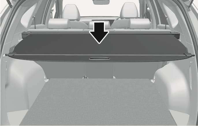 2025 Hyundai Tucson cargo security screen image. The screen is extended across the cargo area. A black arrow points downward to the handle at the center of the screen. Explains the function of using the screen to cover items stored in the cargo area.