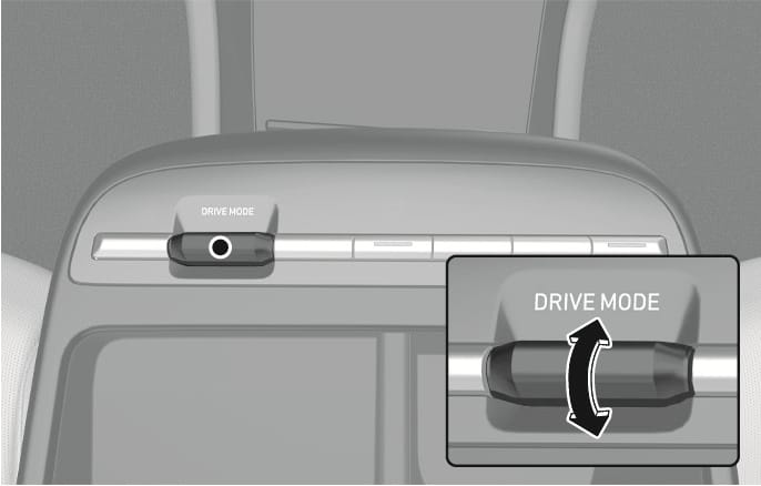 2025 Hyundai Tucson Drive Mode button image. Highlights the DRIVE MODE switch on the center console. A detailed view with a curved double-headed arrow shows the switch toggles up and down. Explains the function of selecting drive modes.