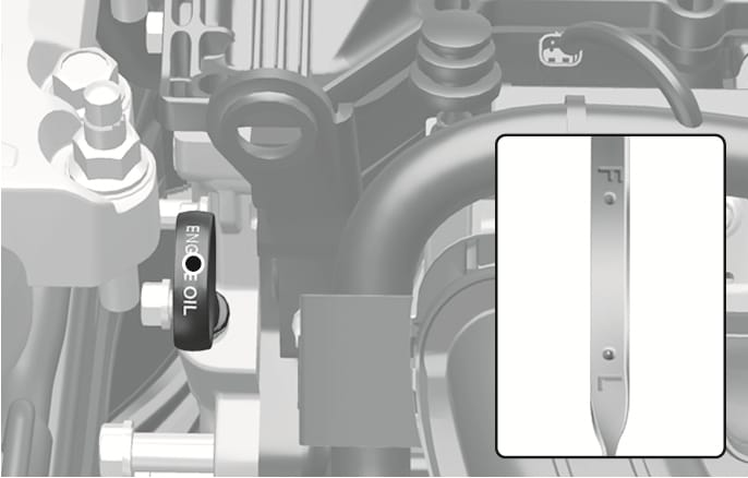 2025 Hyundai Tucson Smartstream G2.0 engine oil dipstick image. The image displays the location of the dipstick handle labeled 'ENGINE OIL' in the engine compartment. A magnified inset shows the dipstick gauge with 'F' and 'L' markings. This explains the function of checking the engine oil level.