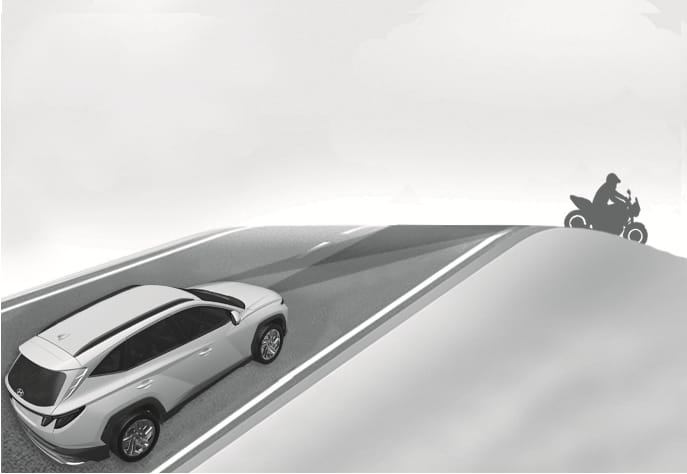 2025 Hyundai Tucson Forward Collision-Avoidance Assist limitation image. A white SUV drives up a hill with a motorcycle over the crest. The sensor beam extends forward but misses the motorcycle due to the slope. Explains the limitation where the system may not detect vehicles ahead on inclined roads.