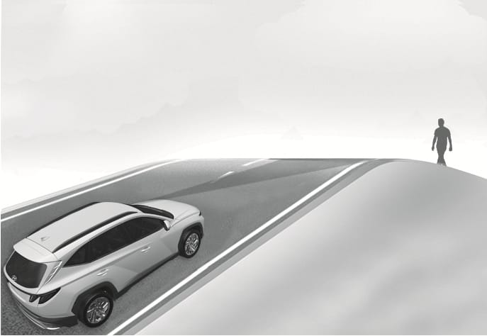 2025 Hyundai Tucson Forward Collision-Avoidance Assist limitation image. A white SUV drives up a steep incline, approaching a pedestrian walking over the crest of the hill who is outside the camera's field of view. This explains the limitation where the system may not detect pedestrians or vehicles on inclined roads.