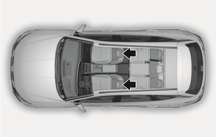 2025 Hyundai Tucson front seat headrests overview image. A top-down view of the interior features black arrows pointing to the headrests on the driver and front passenger seats. Illustrates the location of the adjustable headrests for the front seats.