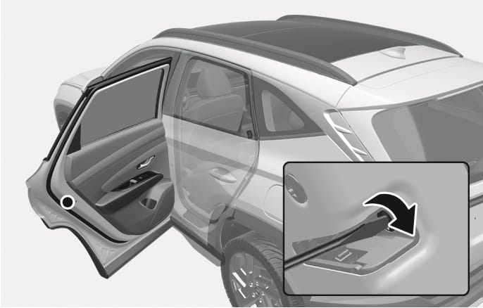2025 Hyundai Tucson emergency door lock image. The image shows an open rear door and a close-up of the lock hole on the edge. A tool is inserted with a curved arrow indicating the turning direction. Explains the function of manually locking the door in an emergency.