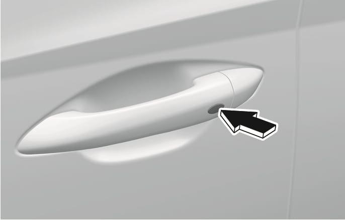 2025 Hyundai Tucson outside door handle button image. A black arrow points to the small button located on the exterior door handle. Explains the function of locking the vehicle by pressing the door handle button.