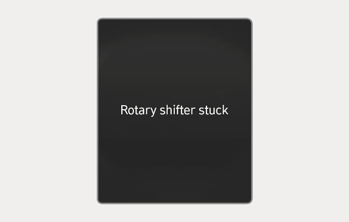 2025 Hyundai Tucson cluster display message image. The text 'Rotary shifter stuck' is displayed in white on a dark background. Explains the warning message displayed when the rotary gear shift dial does not return to its normal position after operation.