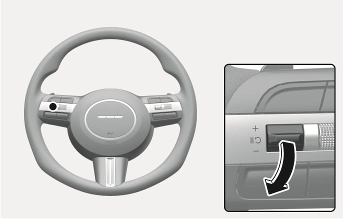 2025 Hyundai Tucson steering wheel speed control switch image. The image highlights the switch on the left spoke. A detailed inset shows a black arrow pointing downwards on the toggle switch labeled with plus and minus signs. This explains the function of pushing the switch down to decrease the set cruise control speed.