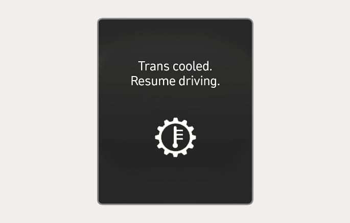 2025 Hyundai Tucson transmission cooled notification image. The instrument cluster displays the text 'Trans cooled. Resume driving.' above a gear icon containing a thermometer. It indicates that the transmission has cooled down and driving can resume.