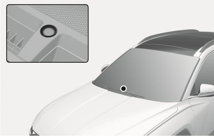 2025 Hyundai Tucson solar radiation sensor image. The image highlights the sensor's location on the upper dashboard near the windshield and provides a close-up view of the round component. Explains the function of detecting solar radiation to automatically adjust the indoor temperature.