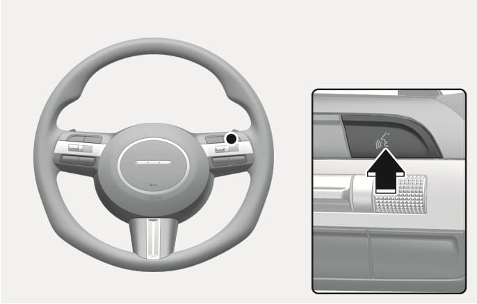 2025 Hyundai Tucson voice recognition button image. The steering wheel is displayed with a close-up of the right-side controls. A black arrow points to the button featuring a face profile with sound waves icon. This explains the function of pressing the button to activate the voice recognition system.
