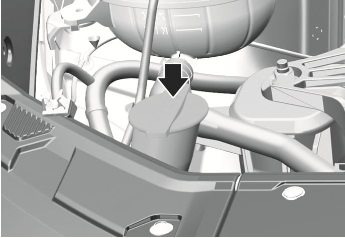 2025 Hyundai Tucson washer fluid reservoir image. A black arrow points downward to the reservoir cap marked with a windshield washer symbol in the engine compartment. Describes the location for checking and refilling the washer fluid.