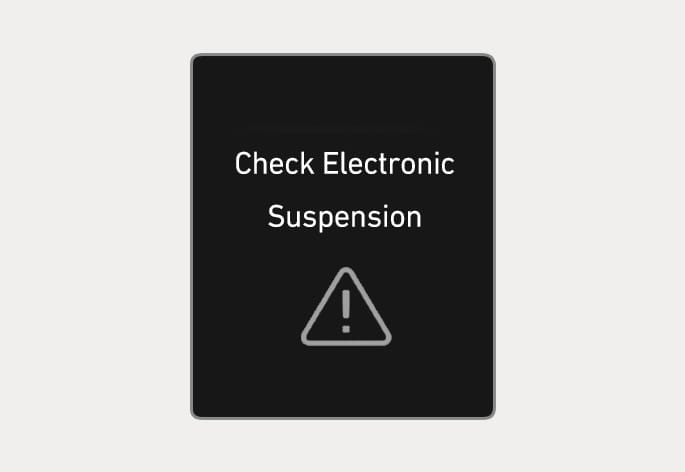 2025 Hyundai Tucson Electronic Control Suspension warning message image. The cluster display shows the text 'Check Electronic Suspension' above a triangle icon with an exclamation mark. This explains the notification displayed when the Electronic Control Suspension is not working properly.