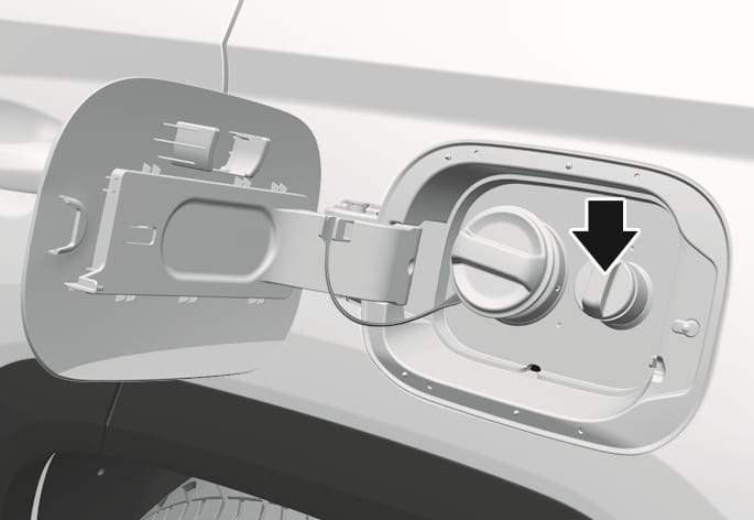 2025 Hyundai Tucson urea solution filler cap image. A black arrow points to the smaller cap located to the right of the fuel filler cap inside the open fuel filler door. This illustrates the location of the urea solution filler neck for refilling.