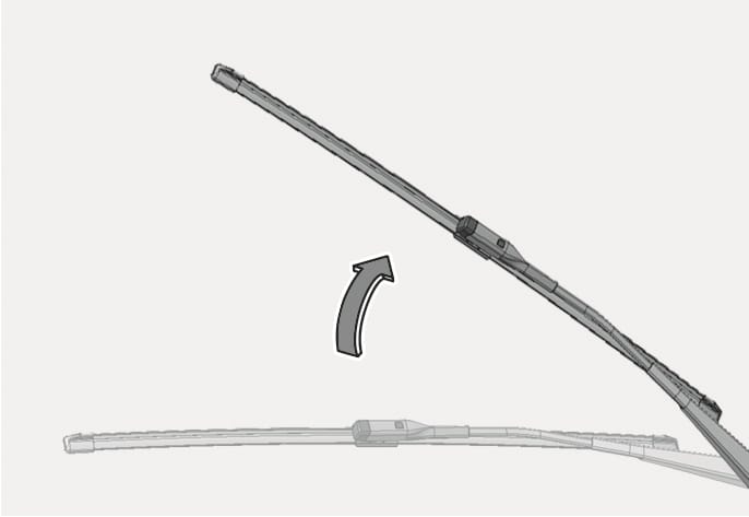 2025 Hyundai Tucson front windshield wiper arm image. A curved arrow points upward from the wiper arm lying on the glass to the arm in a lifted position. Explains the action of raising the wiper arm to replace the blade.