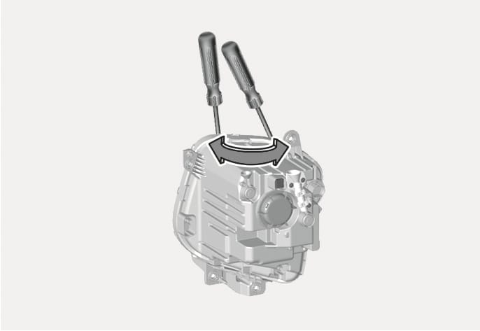 2025 Hyundai Tucson Type B headlight aiming adjustment image. Two screwdrivers are inserted into the adjustment points on the top of the headlight assembly. A curved double-headed arrow indicates the rotation direction. Explains the function of adjusting the headlight aim by turning the drivers clockwise or counterclockwise.