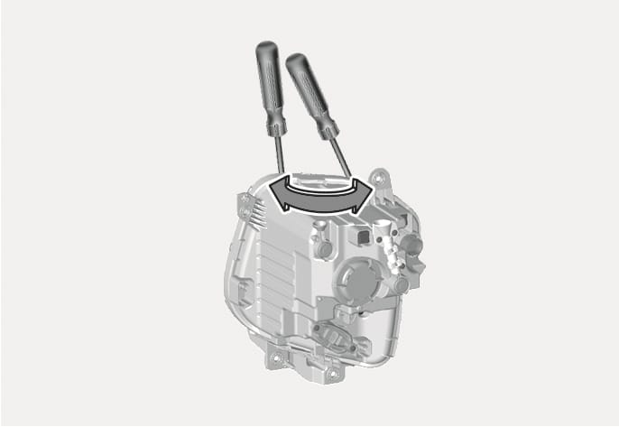 2025 Hyundai Tucson Type A headlight aiming adjustment image. Two screwdrivers are inserted into the adjustment points on the headlight housing, with a curved double-headed arrow indicating rotation. Describes the function of adjusting the headlight beam direction by turning the driver clockwise or counterclockwise.