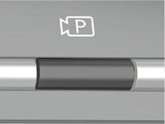 2025 Hyundai Tucson Parking/View button image. The image displays a dark rectangular button on a silver panel, with a camera icon containing the letter 'P' located directly above it. Explains the function of activating the Remote Smart Parking Assist by pressing and holding this button.