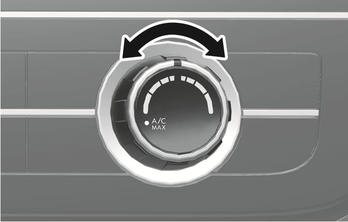 This is an image of the 2025 Hyundai Tucson temperature control knob. The circular dial features a bold, black curved arrow at the top indicating left and right rotation. The knob features temperature control scales and the phrase "A/C MAX." This explains how to turn the knob to set the desired temperature or turn it to the far left to activate maximum cooling.