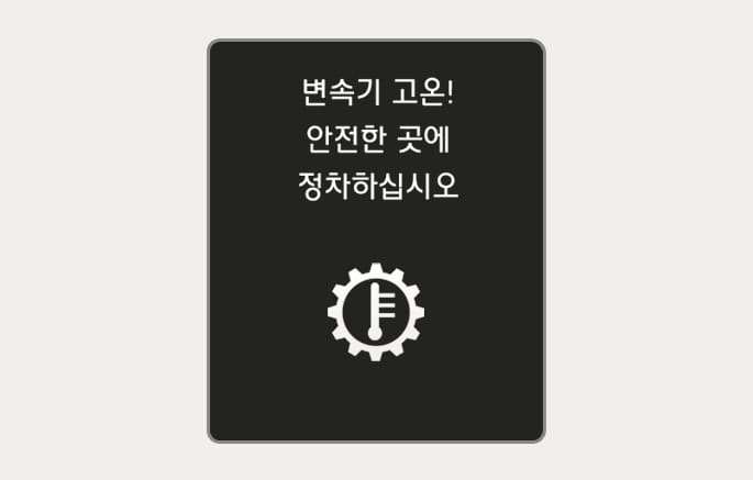 2025 현대 투싼 변속기 고온 경고문 이미지입니다. 클러스터 화면 중앙에 '변속기 고온! 안전한 곳에 정차하십시오'라는 흰색 문구가 표시되어 있으며, 하단에는 톱니바퀴 모양 내부에 온도계가 그려진 아이콘이 위치해 있습니다. 변속기 과열 시 운전자에게 경고하고 안전한 정차를 유도하는 화면 구성을 설명합니다.