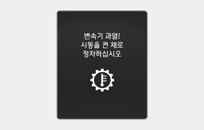 2025 현대 투싼 클러스터 표시창의 변속기 과열 경고 이미지입니다. 검은색 배경 중앙에 '변속기 과열! 시동을 켠 채로 정차하십시오'라는 흰색 문구가 표시되어 있고, 하단에는 톱니바퀴 내부에 온도계가 있는 흰색 아이콘이 위치합니다. 변속기 과열 시 시동을 켠 상태로 정차하여 냉각해야 함을 운전자에게 알리는 화면 구성을 설명합니다.