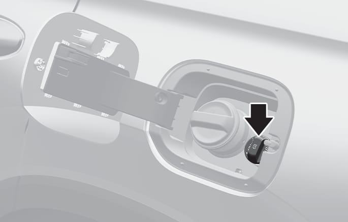 2025 현대 투싼 요소수 탱크 주입구 이미지입니다. 주유구 도어가 열려 있고, 주유 캡 우측 하단에 위치한 요소수 주입구 캡을 굵은 검은색 화살표가 가리키고 있습니다. 요소수를 보충할 때 열어야 하는 캡의 정확한 위치를 안내하는 기능을 설명합니다.